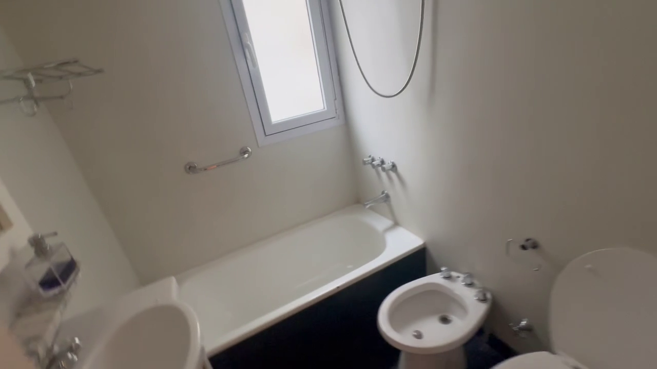 Compact apartment bathroom with bathtub, bidet, and toilet