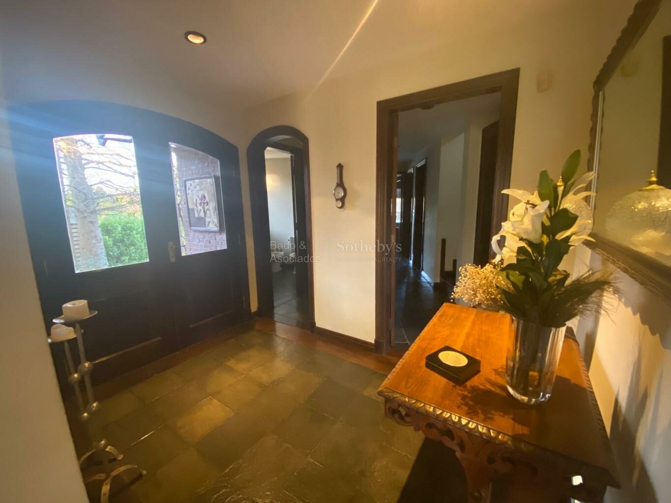 Entrance hall with polished stone flooring and a timber door