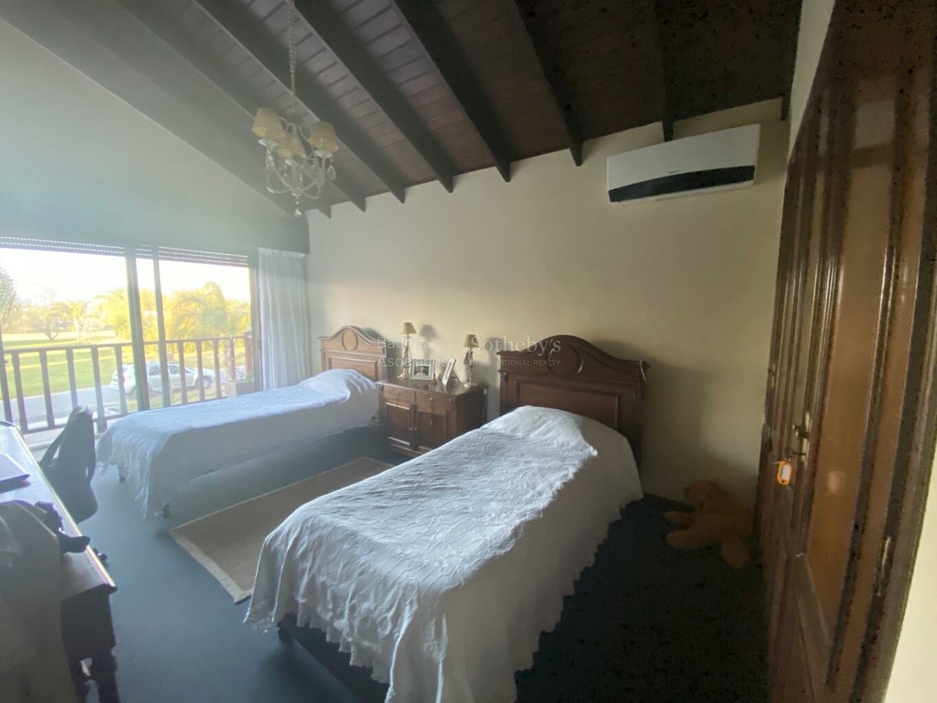 Bedroom with a window and balcony opening to the trees