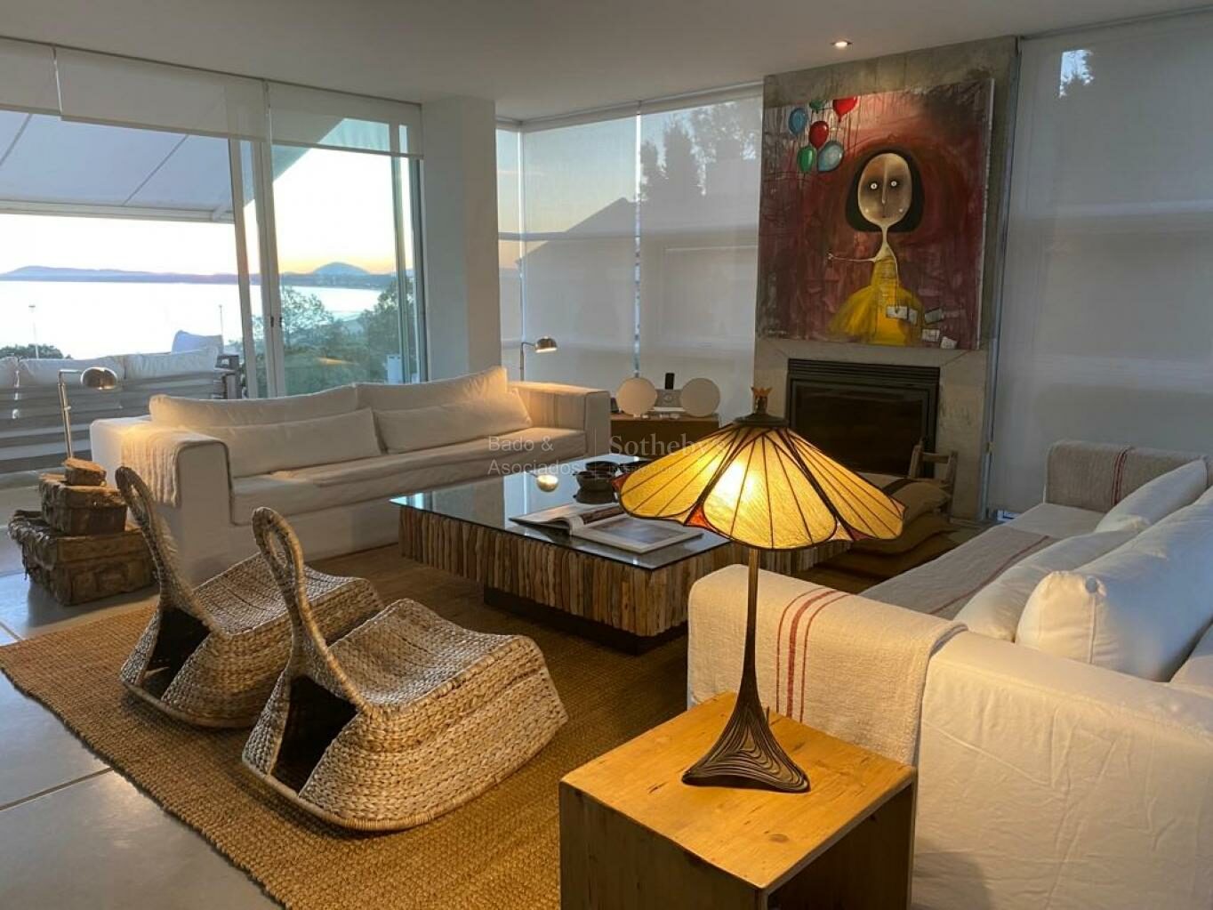Living room with a fireplace and full-height glazing facing the water
