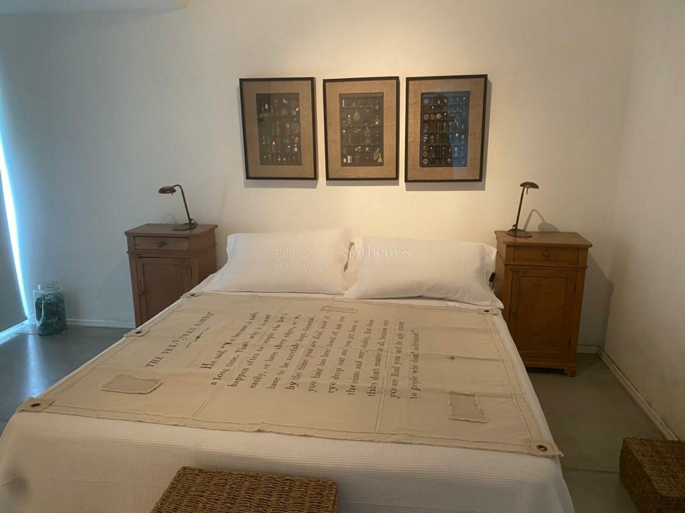 Bedroom with neutral furnishings and framed artwork