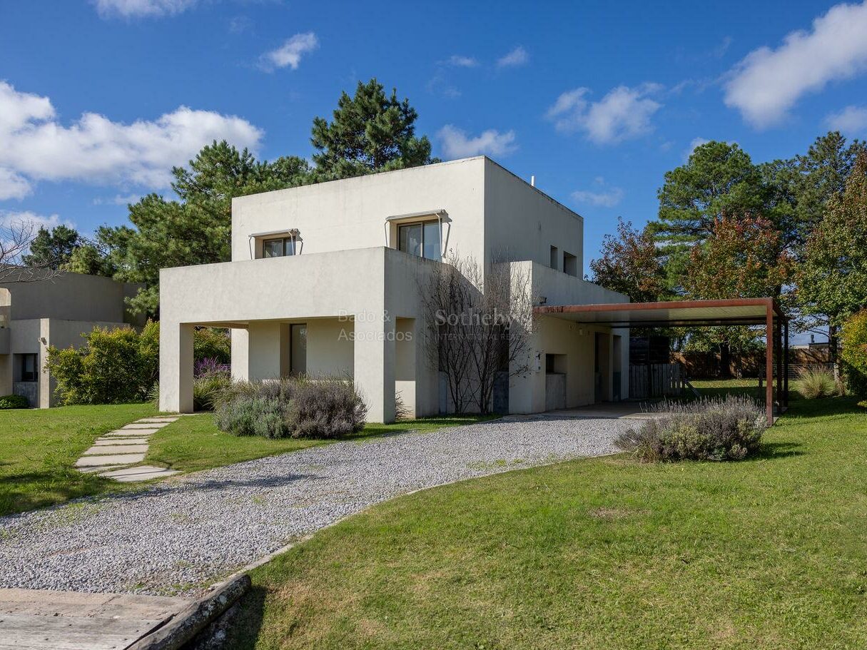 Contemporary house at Viñedos de la Tahona with a gravel drive and lawn
