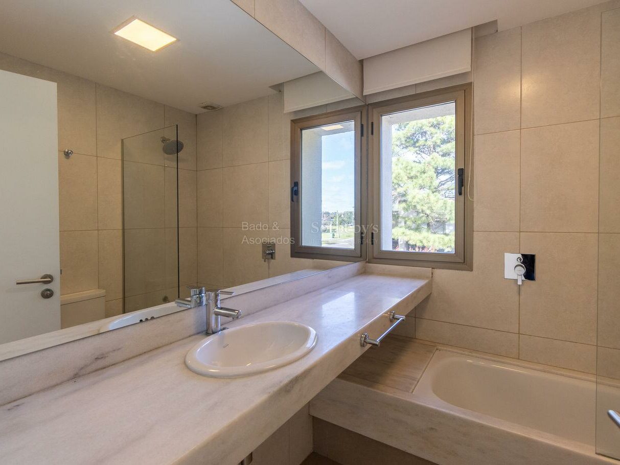 Bathroom with a double basin, bathtub and glass shower enclosure