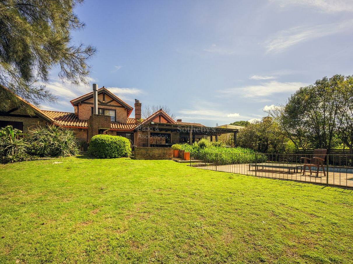 Lawn, house and pool seen together in a wide garden view