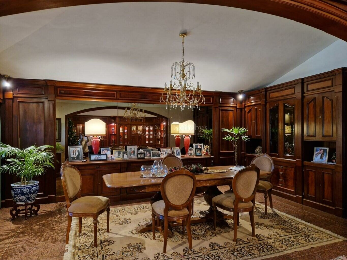 Formal dining room with wood paneling, a large table and built-in cabinetry