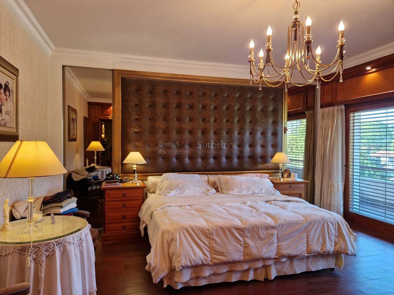 Primary bedroom with a large bed and tall windows