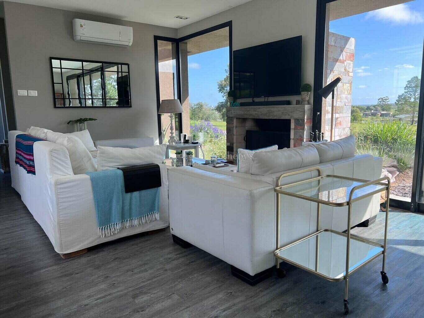 Living room with a sofa, wall-mounted television and stone fireplace