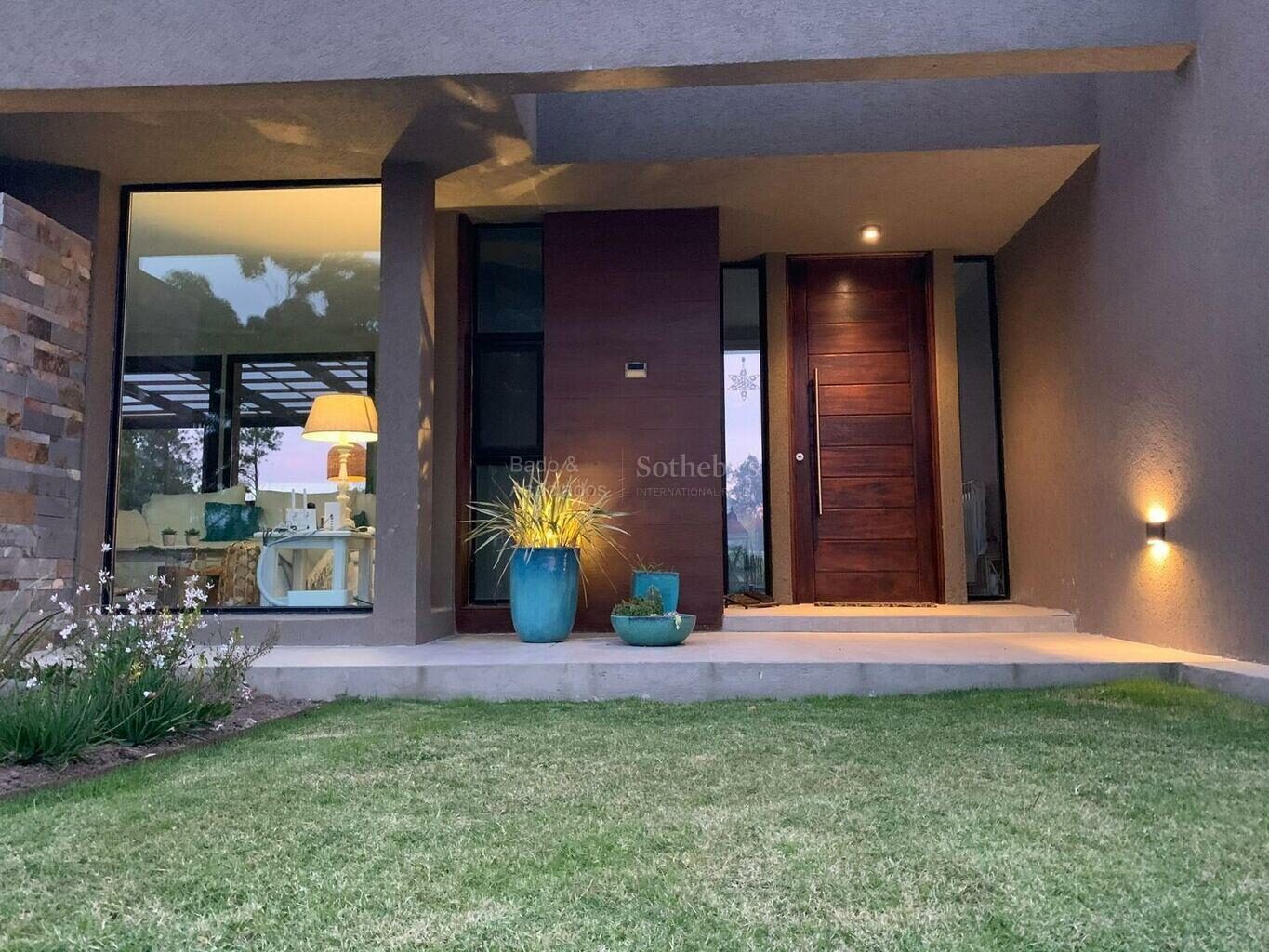 Front entrance of the house with its timber door and planted approach