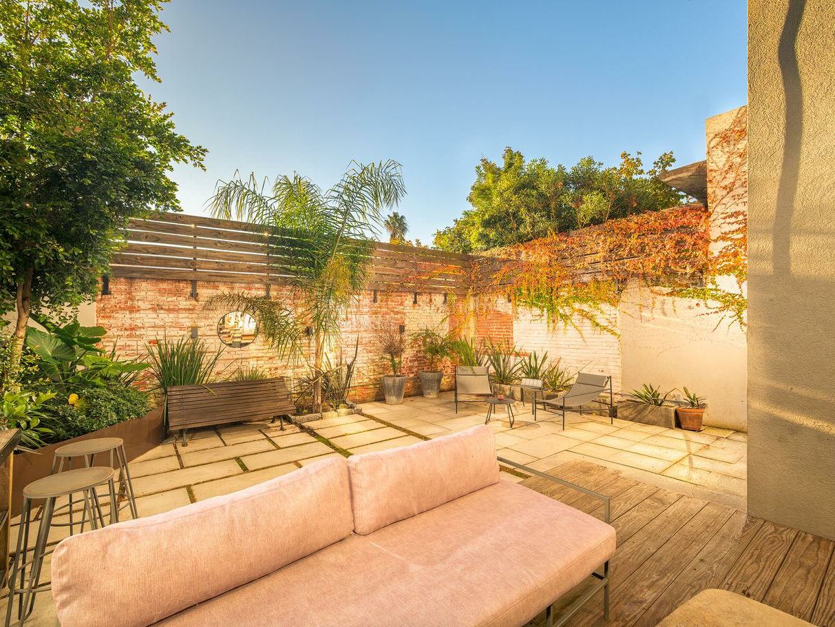 Sunlit private courtyard with a timber deck, planting and outdoor seating