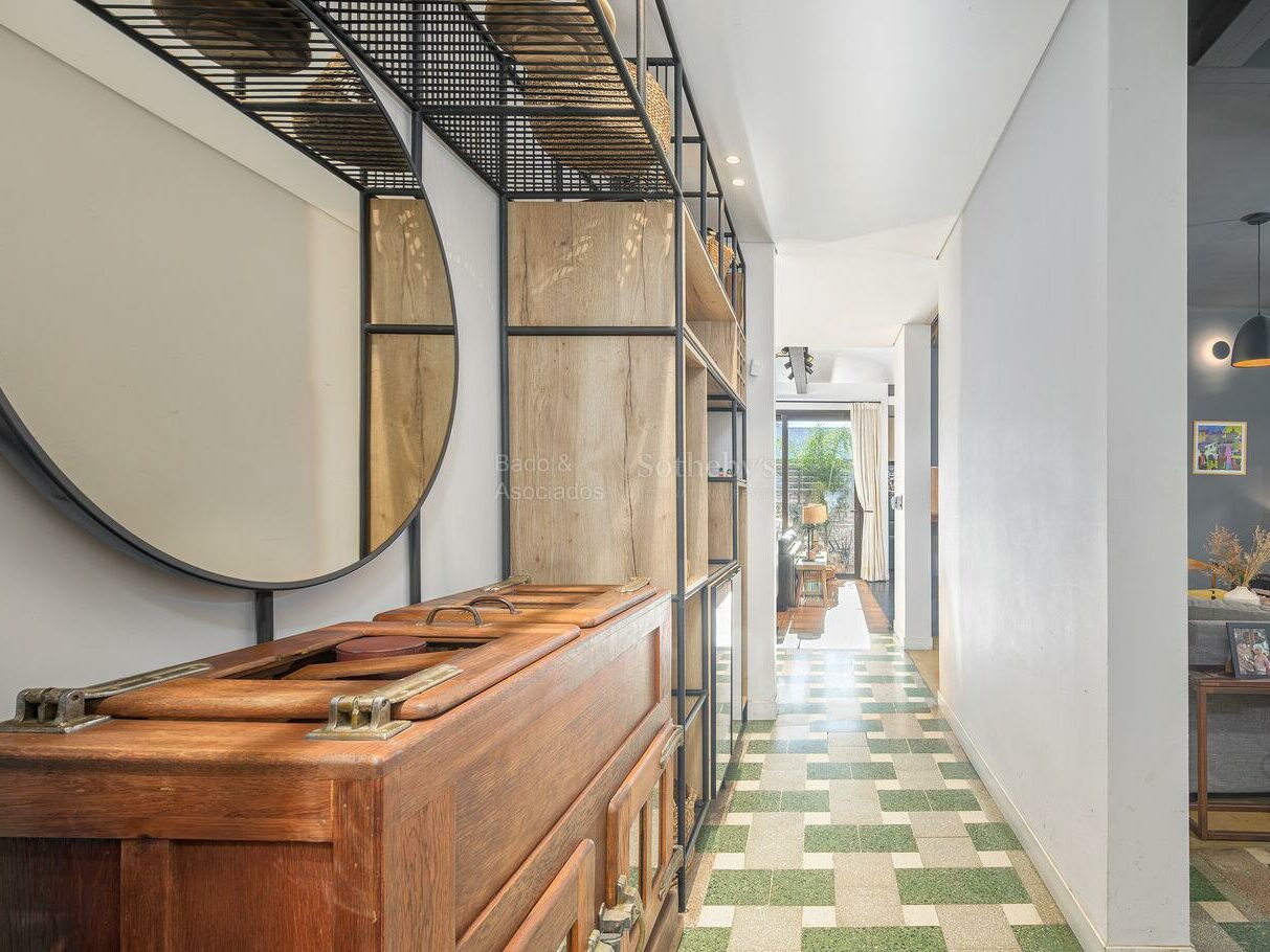 Hallway with black and white checkerboard floor tiles and a round mirror