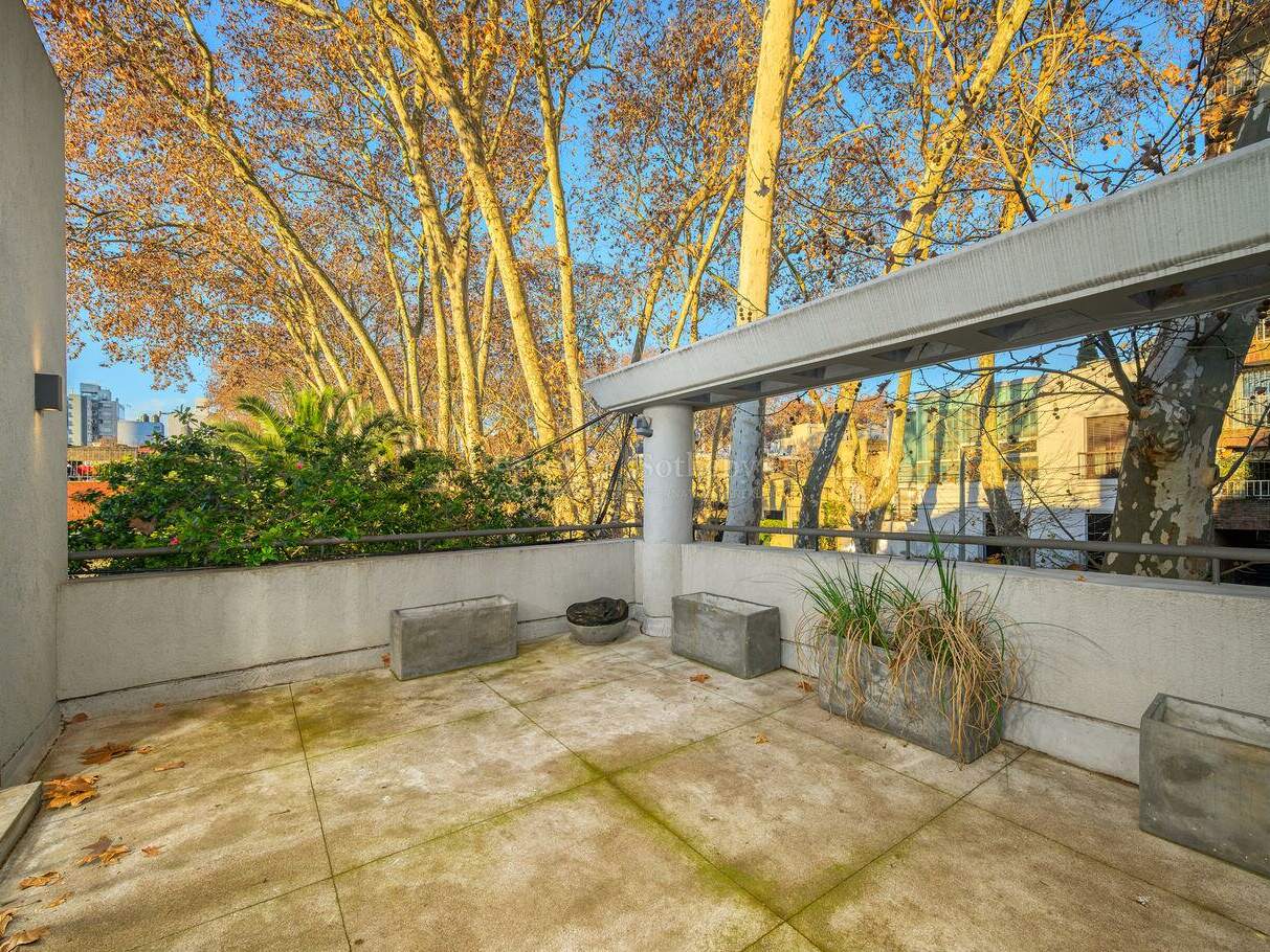 Elevated terrace with planters and an outlook over neighbouring buildings
