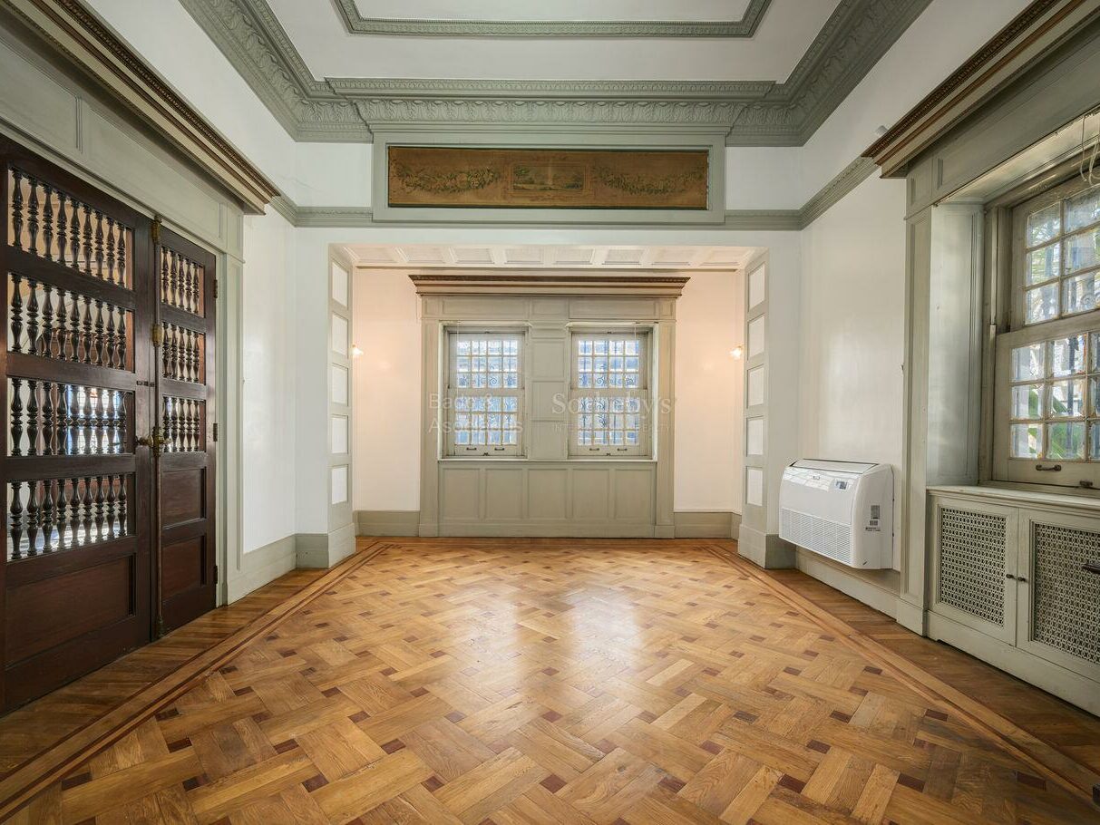 Period reception room with tall windows, parquet and ornate mouldings