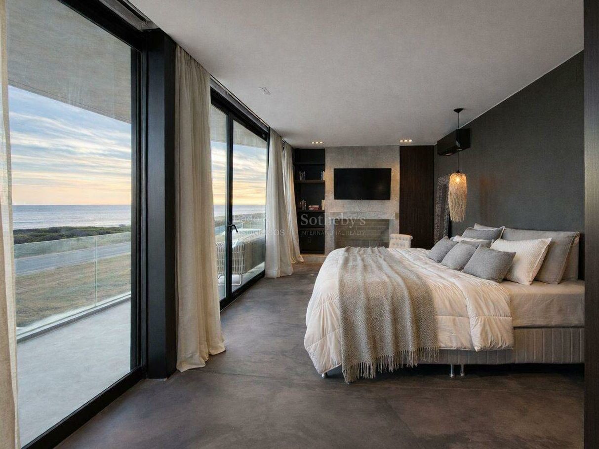 Bedroom with glazed doors opening to a balcony and sea outlook