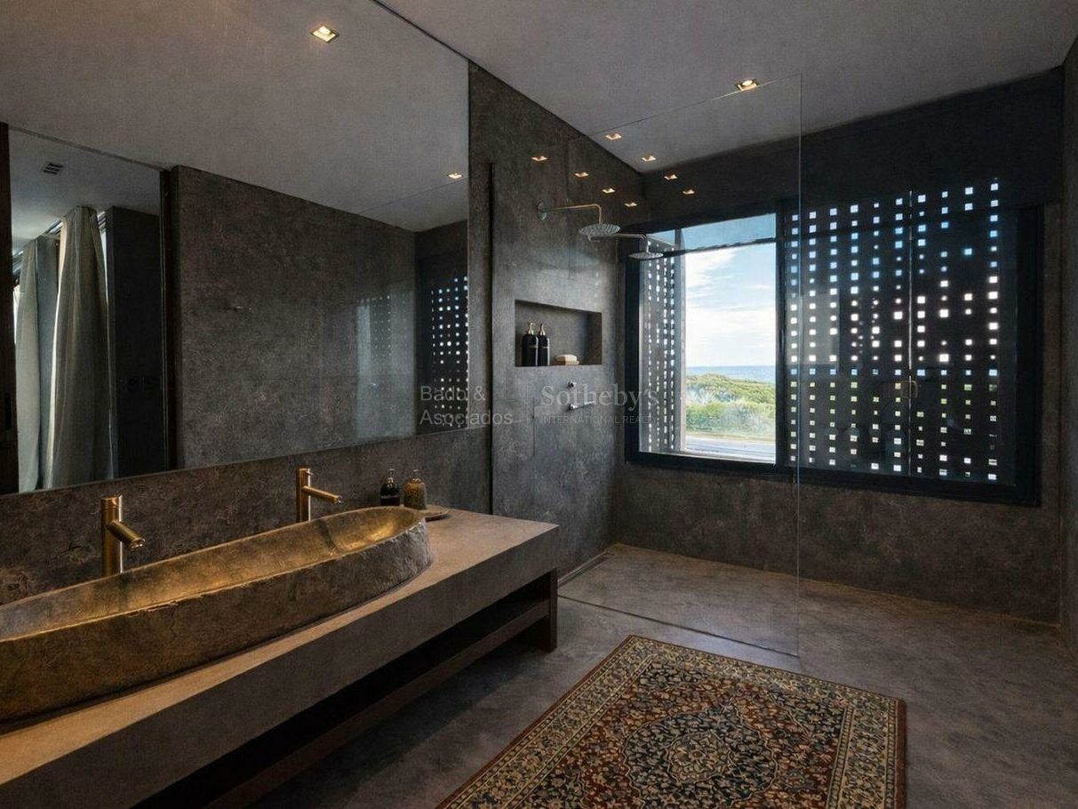 Bathroom finished in dark stone with a freestanding bath