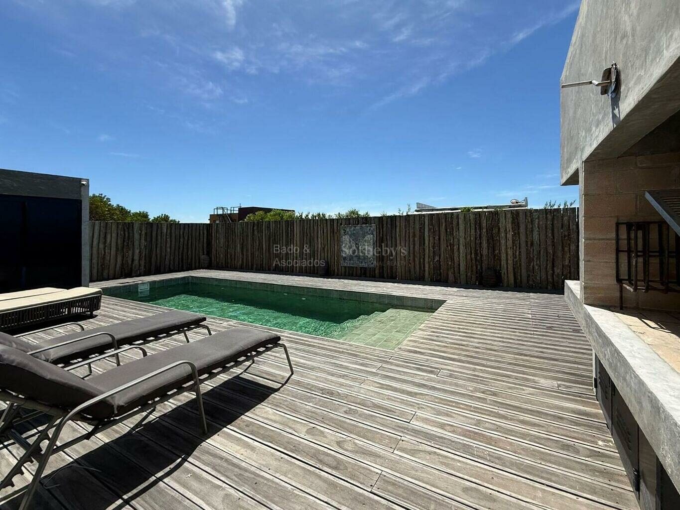 Wide pool terrace with timber decking and an outdoor barbecue area