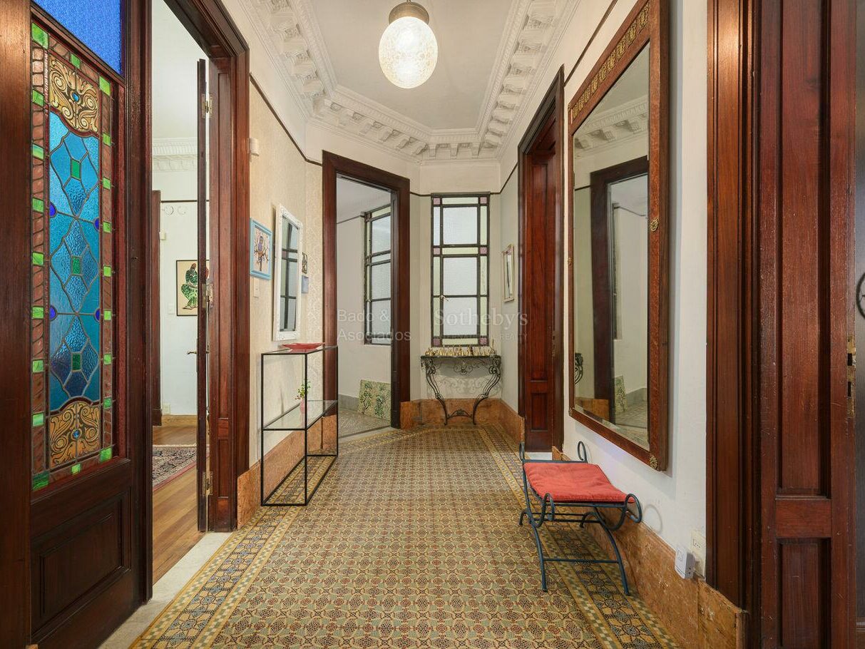 Entrance hall of the San Felipe y Santiago apartment with stained glass and patterned tile floors